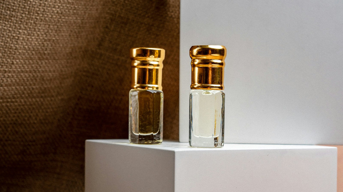 Dve malé sklenené vzorkovnice so zlatými uzávermi