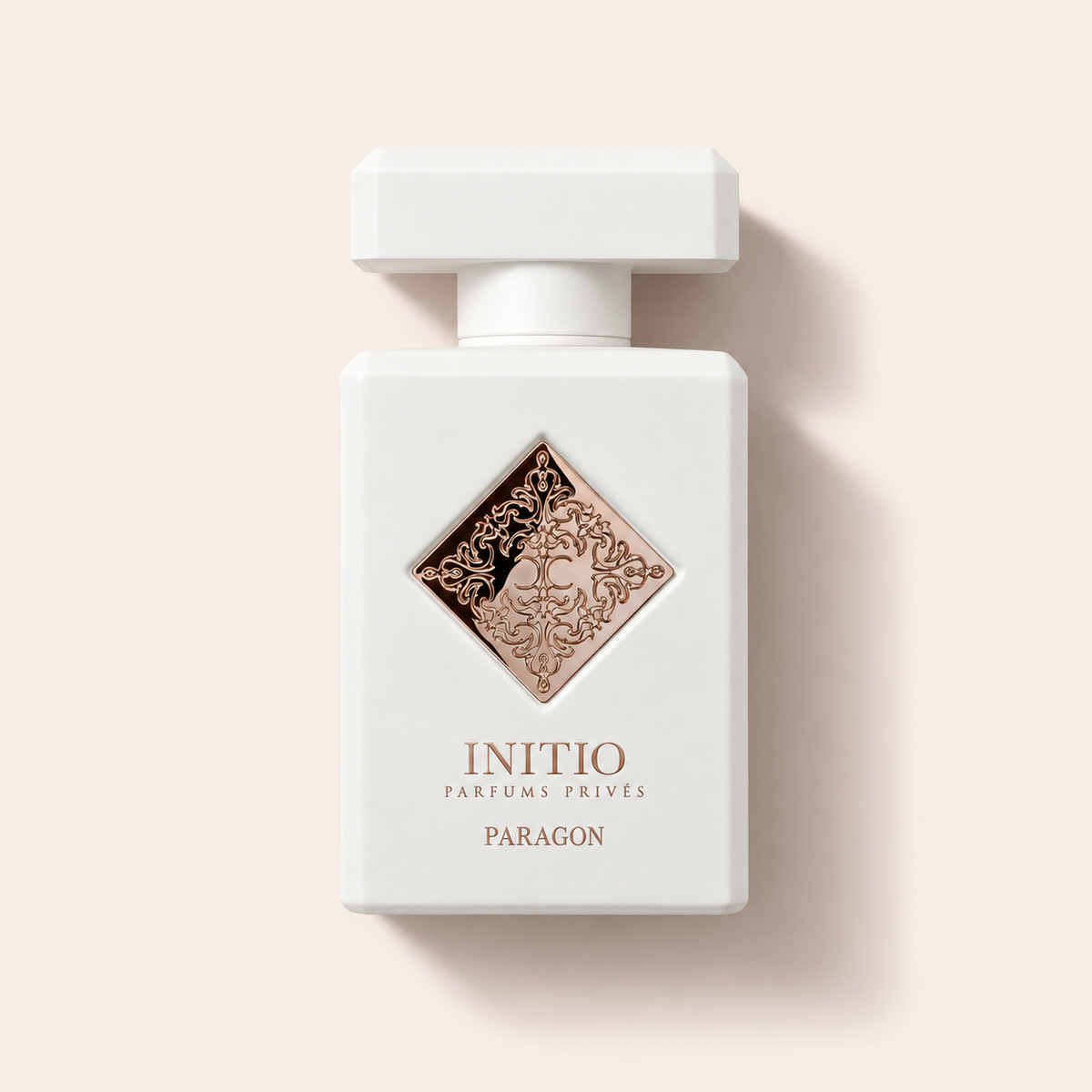 Flakon Initio Paragon Extrait 90 ml na pudrově růžovém pozadí – MrRizz