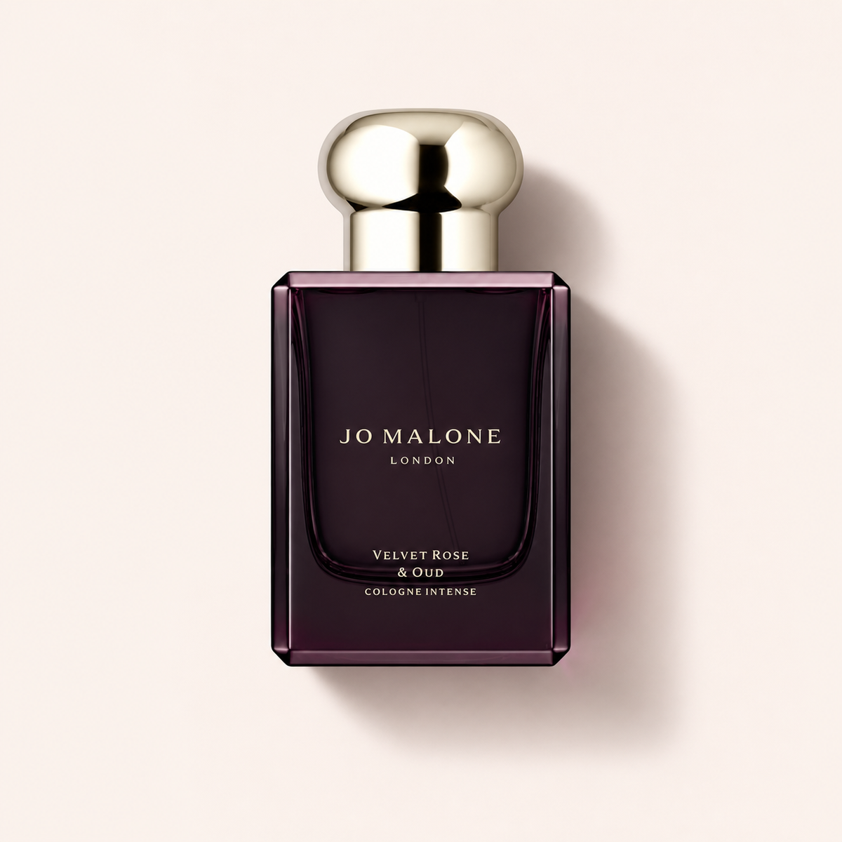 Flakon Jo Malone Velvet Rose & Oud Cologne Intense 50 ml na pudrově růžovém pozadí – MrRizz