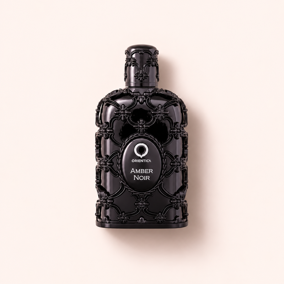 Orientica Luxury Collection Amber Noir EDP 80 ml na teplém růžovém pozadí – MrRizz